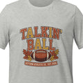 Athletic heather unisex t-shirt printed with bold stacked lettering reading Talkin' Ball above a football and autumn leaves with a small banner beneath