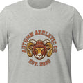Athletic heather unisex t-shirt printed with a vintage circular crest: the words Autumn Athletic Co. arched around a bighorn ram wearing a leather football helmet, framed by wheat laurels above Est. 2026