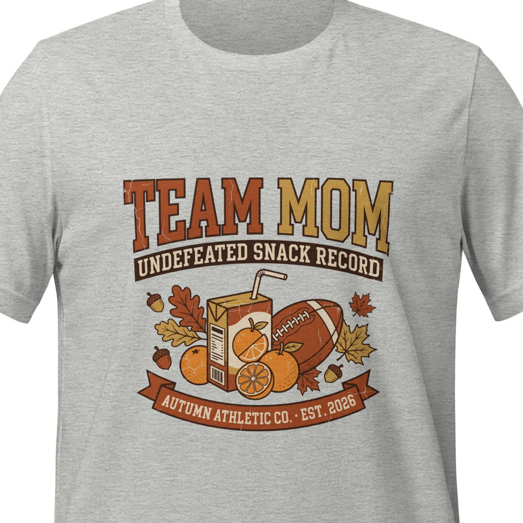 Athletic heather unisex t-shirt printed with bold lettering reading Team Mom above a plaque reading Undefeated Snack Record, with orange slices, a juice box and a football